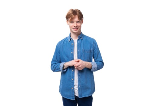 young redhead man in a stylish blue shirt on a white background with copy space.
