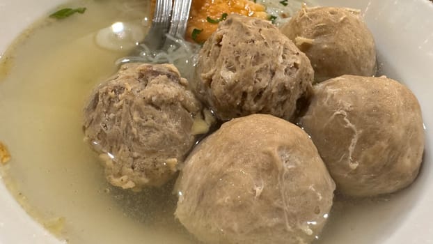 super delicious, tender and juicy and spicy bites of beef tendon meatballs in a bowl in Indonesian street food