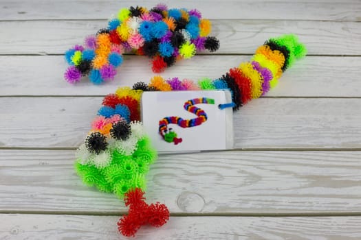 Snake toy made from sticky construction set, colored fluffy balls with hooks for child