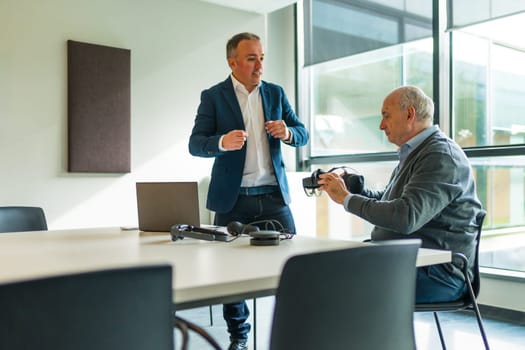 Businessman presenting a new innovative virtual reality goggles to a client in the office