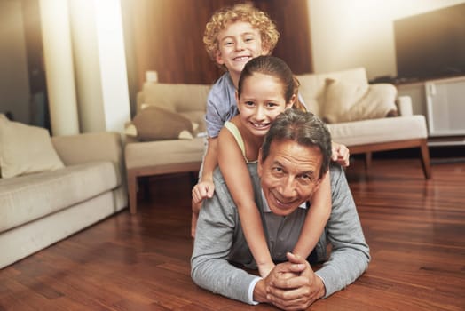 Portrait, home and grandfather on the floor, grandkids and happiness with stack and holiday. Face, apartment and elderly man with grandchildren or bonding together with love and playing with siblings.