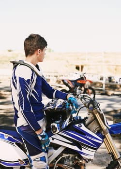 Motorcycle, extreme sport and man for race on trail for competition, vision or games with speed. Racer, motorbike and thinking for contest, motor cross and fast transportation with sunshine in desert.