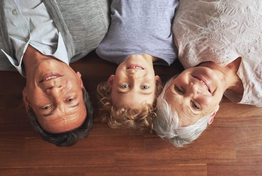Portrait, grandparents and boy on the floor, love and bonding together with joy or apartment. Family, face or old man with elderly woman, kid or grandchild with fun or cheerful with home or vacation.