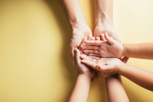 Family hands stacked in close-up top view isolated background. Parents and child holding empty space symbolize support and love. Embracing togetherness trust and community.