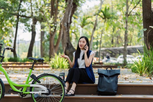 asian young businesswoman use smart phone while commuting in city. Eco friendly.