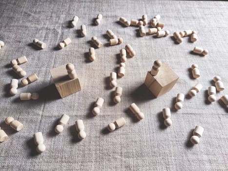 Wooden toys stand opposite and lot of lying figures. Concept of dispute between leaders of two groups. Government and deaths of citizens and soldiers. War in Russia, Ukraine, Israel, Palestine