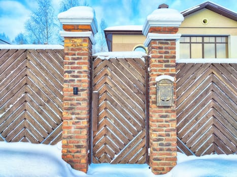 New gate, entrance to a private territory on a winter day and snow. Metallic texture and background. Fence