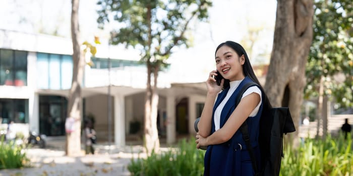 Young happy Asian business woman office professional talk cellphone in walking on city go work.