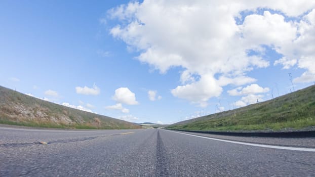 On a clear winter day, a car smoothly travels along Highway 101 near Santa Maria, California, under a brilliant blue sky, surrounded by a blend of greenery and golden hues.