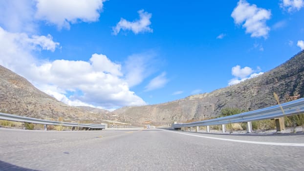 Vehicle is cruising along the Cuyama Highway under the bright sun. The surrounding landscape is illuminated by the radiant sunshine, creating a picturesque and inviting scene as the car travels through this captivating area.