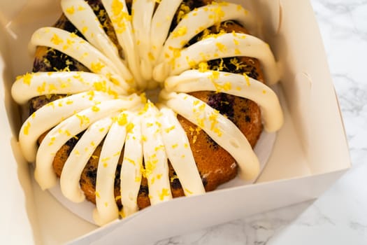 The freshly baked bundt cakes are carefully nestled into white paper boxes, preparing them for secure transportation while maintaining their delectable appearance.