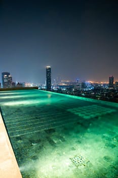 Rooftop pool with Bangkok skyline view at sunset, in Bangkok Thailand, south east asia