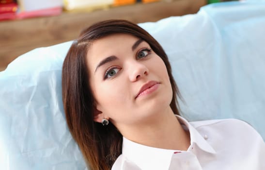 A woman at the reception of a male dentist examining teeth and oral cavity