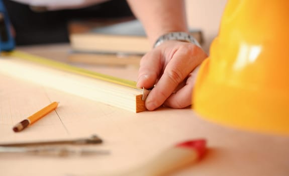 Arms of worker measuring wooden bar portrait. Manual job DIY inspiration improvement job fix shop yellow helmet joinery startup workplace idea hard hat career ruler industrial education