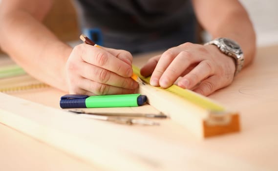 Arms of worker measuring wooden bar portrait. Manual job DIY inspiration improvement job fix shop yellow helmet joinery startup workplace idea hard hat career ruler industrial education