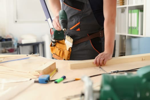 Arms of worker using electric drill closeup. Manual job DIY inspiration improvement job fix shop yellow helmet joinery startup idea industrial education profession career concept