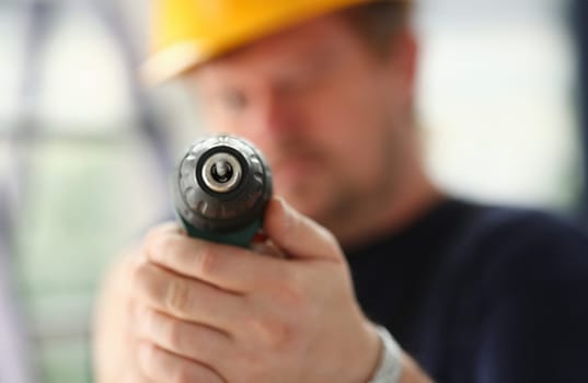 Arms of worker using electric drill closeup. Manual job DIY inspiration improvement job fix shop yellow helmet joinery startup idea industrial education profession career concept