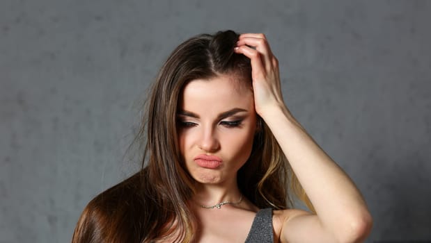 Beautiful european woman portrait. Worth a gray background and smiling beauty fashion style curly hair with white strands view of the eye in the camera