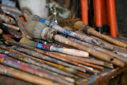Many used dirty brushes of the artist in the workshop