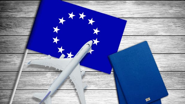 Europe concept. Text near passport cover and european flag on white dark wooden background top view. High quality photo