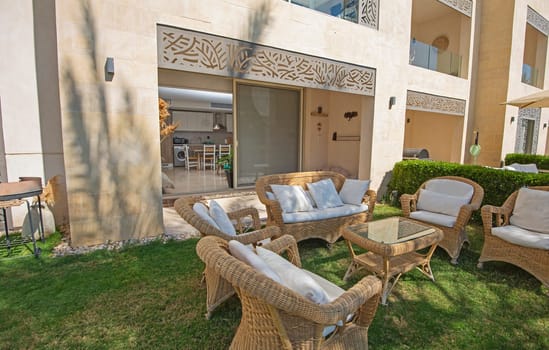 Garden patio area of a luxury apartment in tropical resort with furniture and sliding door