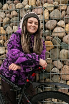 A pretty young woman with piercings and dreadlocks bought a new speed bike for the city.