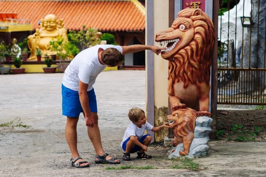 Father and son tourists walking in Vietnam Buddhist Temple, happy childhood, exploring world.