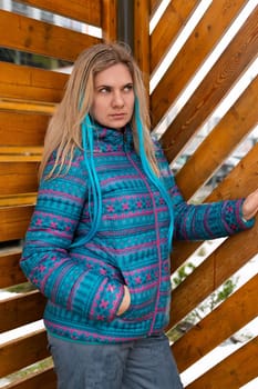 Cute young woman with a colored strand in her hair walks in winter.