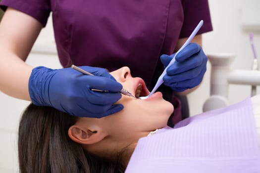 A patient is having their teeth examined by the dentist at the dental office