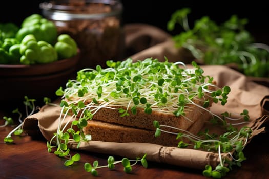 Useful microgreens on the table in the kitchen, growing microgreens at home. Pieces of bread are covered with green microgreens for a healthy breakfast.