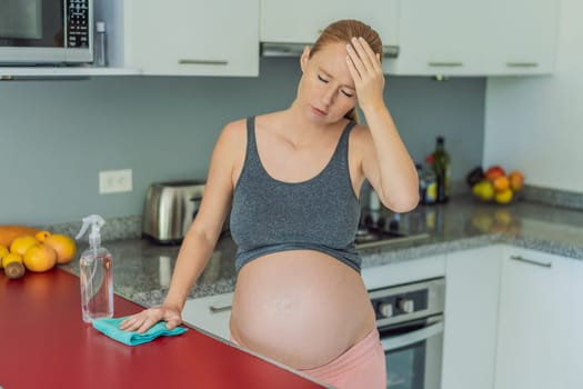 A tired pregnant woman sits in the kitchen after cleaning. Health and vitality of a pregnant woman.