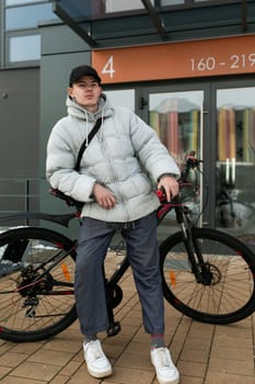 European man walking around the city with a bicycle in winter.
