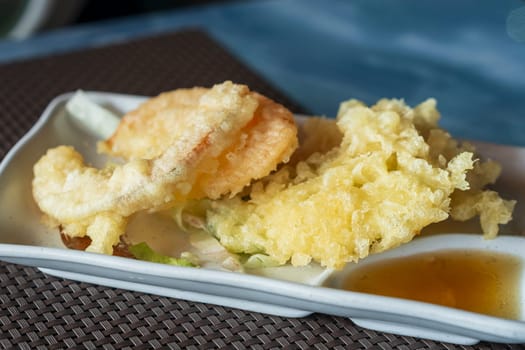 Close up view of prepared Japanese vegetable tempura recipe with ginger ponzu sauce.