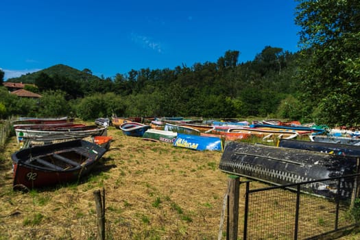 Boats are stored outdoors on the grass