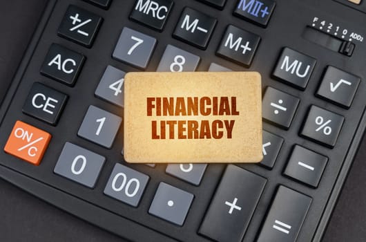 Financial concept. There is a sign on the calculator that says - Financial literacy