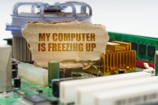 On the computer motherboard there is a cardboard with the inscription - My computer is freezing up. Computer repair concept.