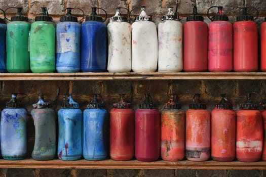 Jars with acrylic paints at a workshop of artist