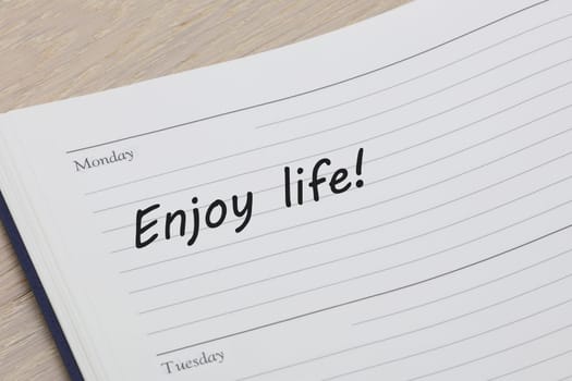 An Enjoy life reminder message in an open diary