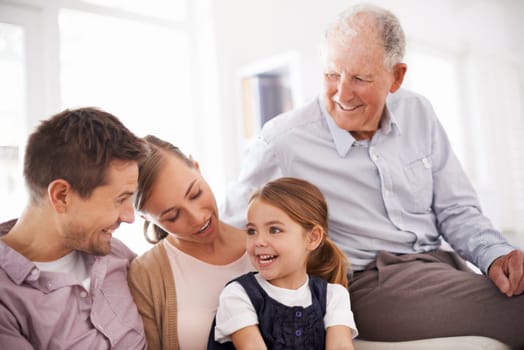 Parents, grandfather and child with happiness on sofa for healthy development, security or comfort in apartment. Family, men and woman with girl kid, smile and bonding for parenting and love in house.