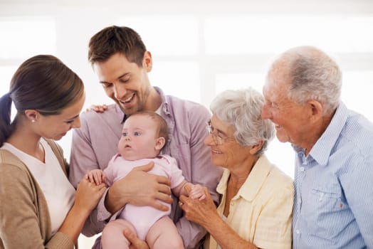 Parents, grandparents and baby with happiness in home for healthy development, security and comfort in apartment. Family, men and women with infant, smile and embrace for parenting, bonding and love.