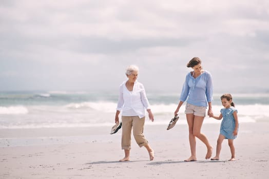 Mother, child and grandmother on beach holding hands for walking explore for holiday, vacation or environment. Family, woman and travel seaside in Australia for weekend bonding, peace or adventure.