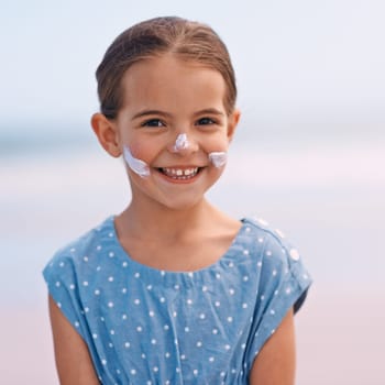 Little girl, portrait and outdoors with sunscreen, smile and cheerful on holiday vacation. Young daughter, happy and cute confidence for getaway, fun and sunblock for protection and summertime.
