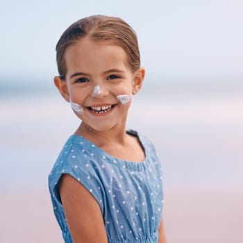 Young child, portrait and outdoors with sunscreen, smile and cheerful on holiday vacation. Little girl, happy and cute confidence for getaway, fun and skincare for protection and summertime.