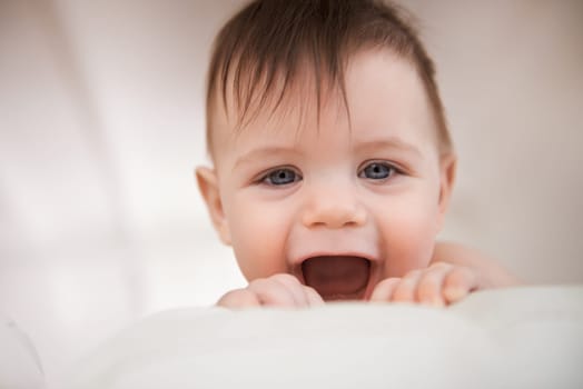Baby boy, excited smile and happy for play, growth and development for childhood. Adorable infant, young and healthy kid at home with face expression, learning motor skills and comfortable in house.