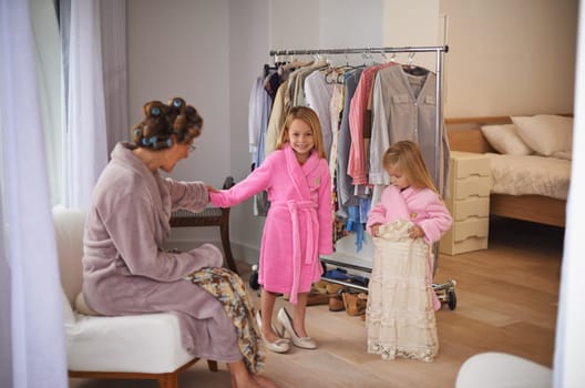Dress up, fun and mother with children in home for makeover, getting ready and clothing. Family, wardrobe and mom and young girls with outfit, style and fashion for bonding, hairstyle and cosmetics.
