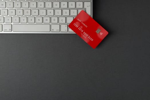 Top view of computer keyboard and credit card on dark gray table