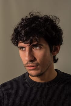 A close up, head shot of a handsome young man with green eyeswearing a black shirt