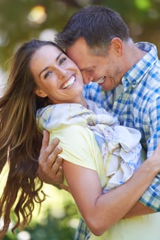 Couple, portrait and bonding with care in garden together, hug and romance for relationship with commitment. Man, woman and affection for dating with love, happy and spouse for comfort in nature.