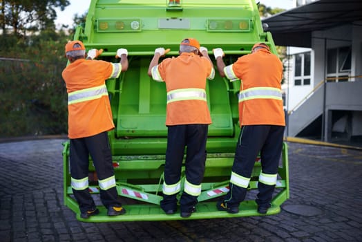 Men, garbage truck and waste collection service for city pollution for cleaning, environment or teamwork. Male people, back and dirt transportation for sidewalk debris in New York, mess or litter.