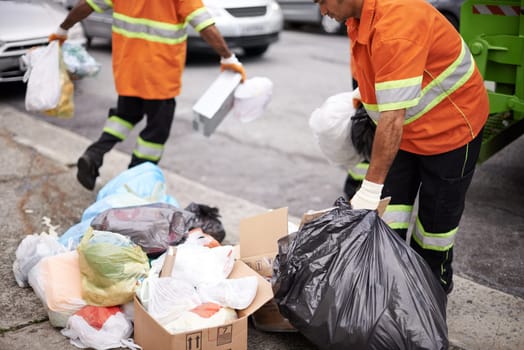 Worker, street and bag of trash in city for cleaning, recycling and waste management with teamwork. Road, pollution and people with garbage for maintenance, service and transportation of dirt.